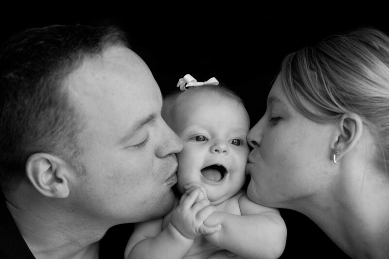 mommy-and-daddy-kissing-baby-small (1)