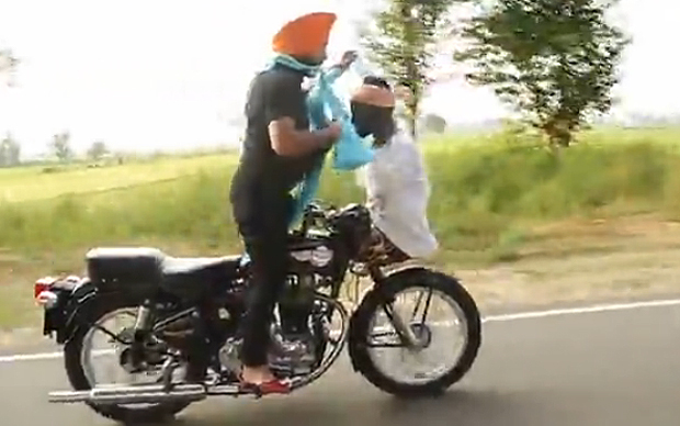 motorcyclist-ties-a-turban-while-driving-with-no-hands