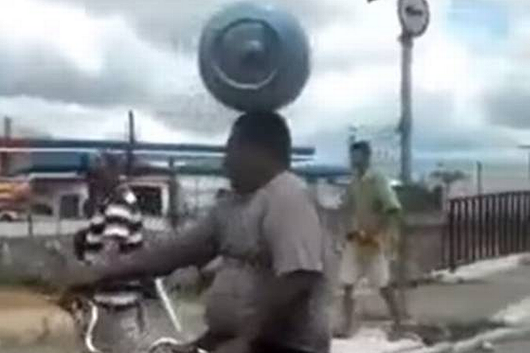 cyclist-balances-gas-canister-on-his-head-while-riding