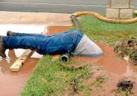 a-plumber-dives-into-muddy-bog-to-fix-a-pipe