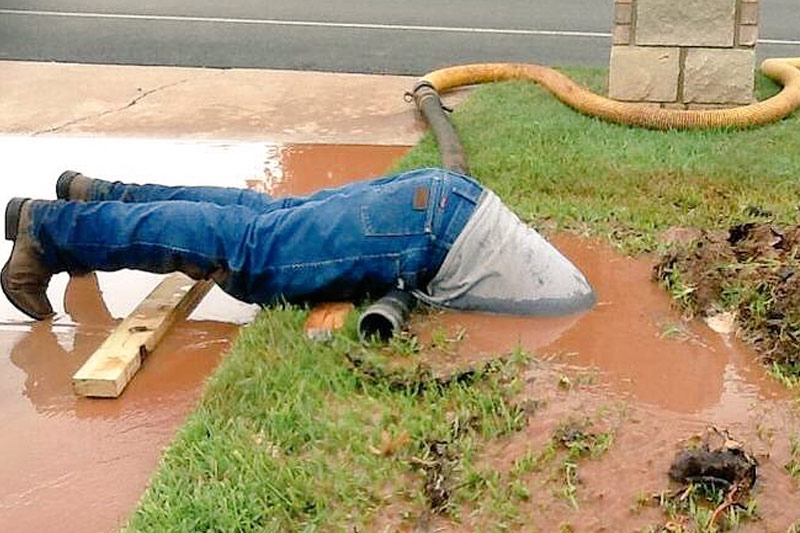 a-plumber-dives-into-muddy-bog-to-fix-a-pipe